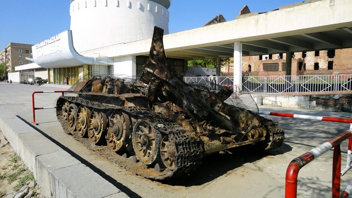Destroyed tank in front of a building