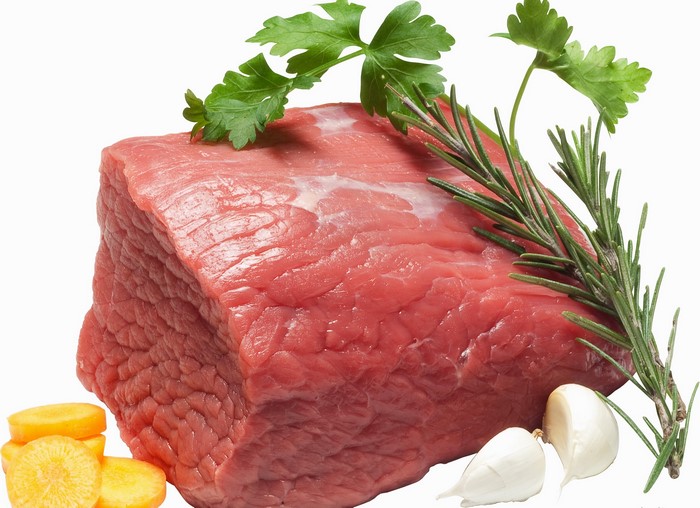 Raw beef roast with herbs, garlic, and carrots