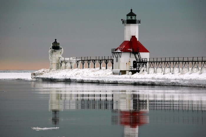 Two lighthouses on a pier covered in ice