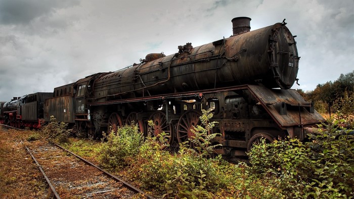 Abandoned rusty steam locomotive on tracks