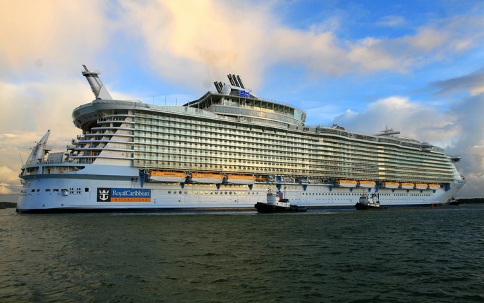 Royal Caribbean International cruise liner with tugboats