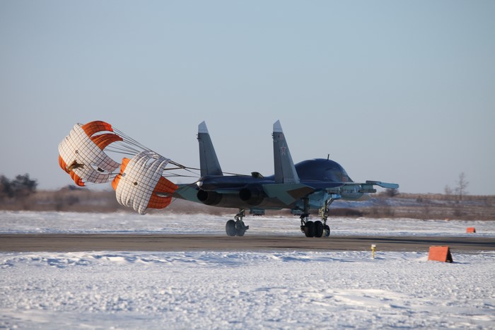 Airplane with drag parachute on runway