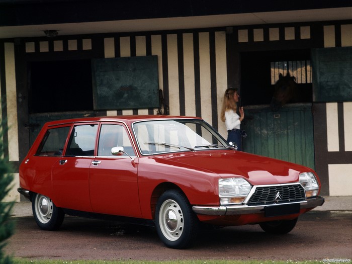 Red Citroen GS Break parked outside a stable with a woman and horse