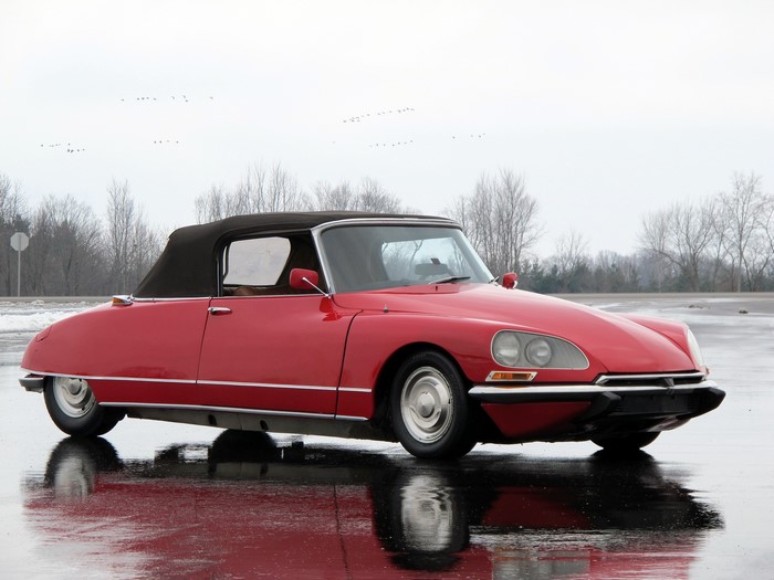 Red Citroen DS convertible parked on wet surface