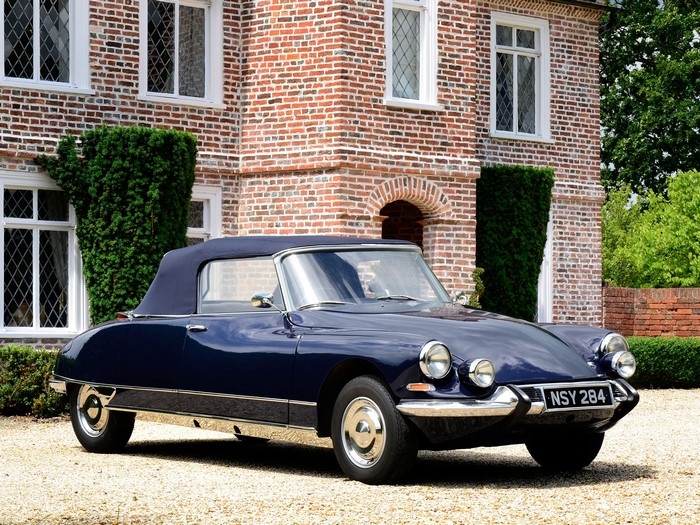 Dark blue Citroen DS convertible parked in front of a brick house
