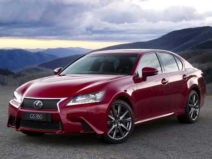 Red Lexus GS 350 sedan parked on a gravel road with mountains in the background