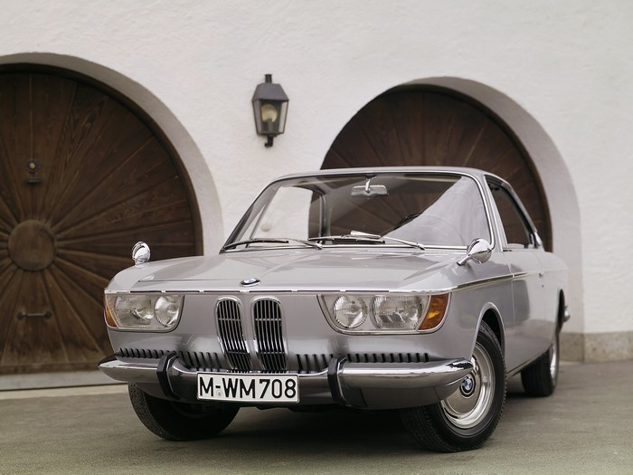 Silver BMW car parked in front of a building