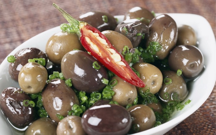 Bowl of olives with chili pepper and chives