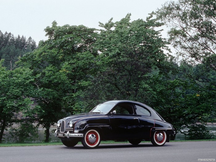 Black Saab 93 parked on a road with trees