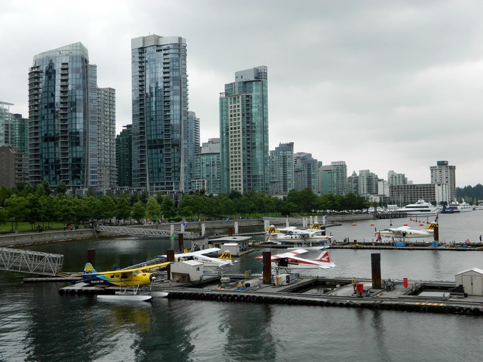 Seaplanes docked in Vancouver harbor with city skyline