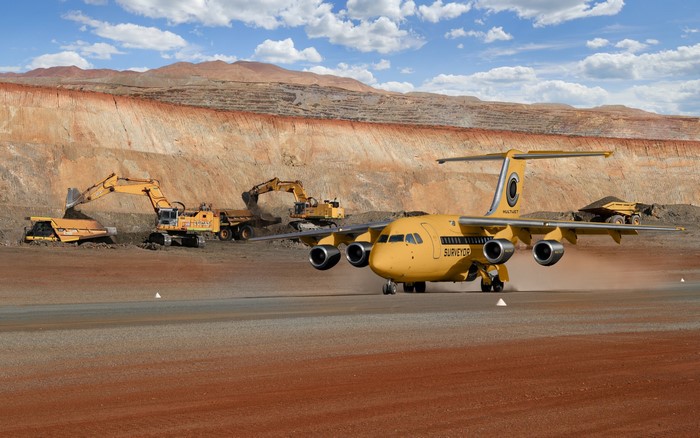 Yellow airplane on a dirt runway at a mine