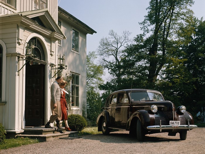 Couple by a Volvo car outside a house