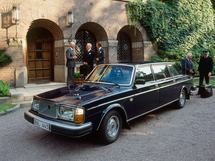 Volvo 240 Estate Limousine with men outside building