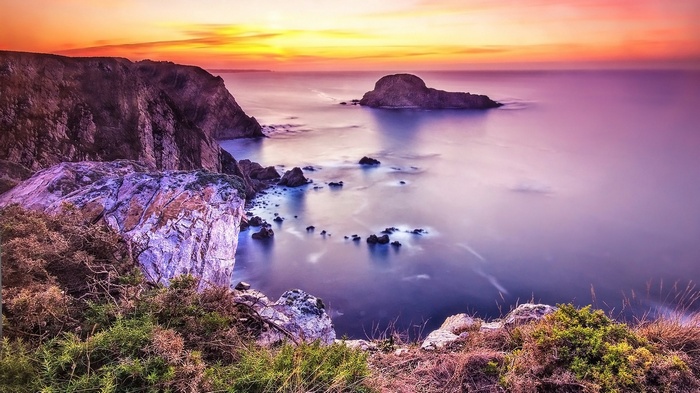 Coastal cliffs at sunset with ocean and rock formations