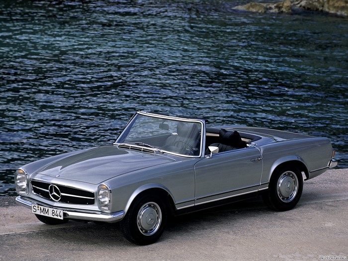 Silver Mercedes-Benz SL convertible by the water