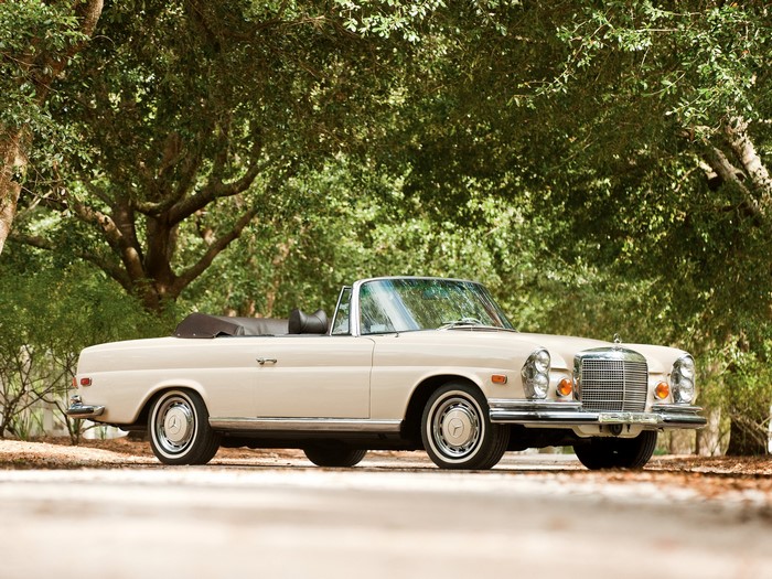 Cream Mercedes-Benz convertible parked under trees