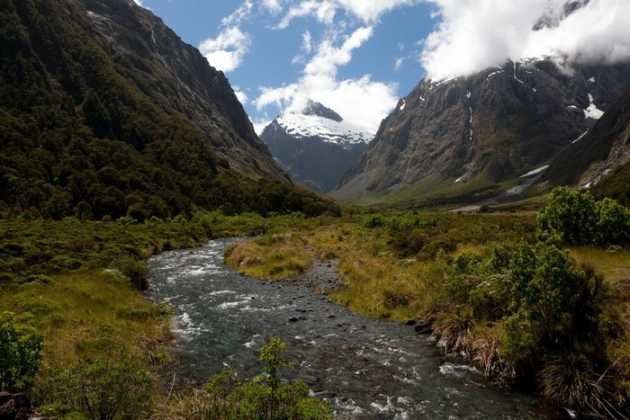 River flowing through a valley with snow-capped mountains