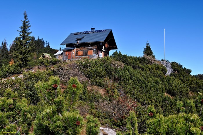 Wooden cabin with solar panels in Austrian mountains