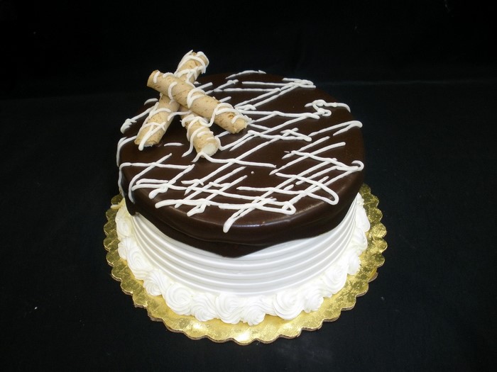 Chocolate cake with white frosting and wafer sticks