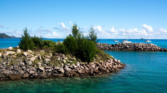 Tropical island with boats and rocky shore
