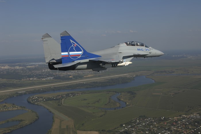 Mikoyan MiG-35 fighter jet in flight over landscape