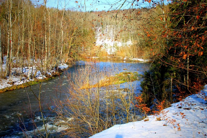 River flowing through a snowy forest in winter
