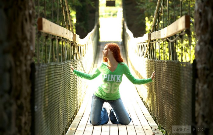 Redhead girl on a suspension bridge