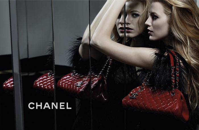 Chanel advertisement featuring a woman with a red handbag