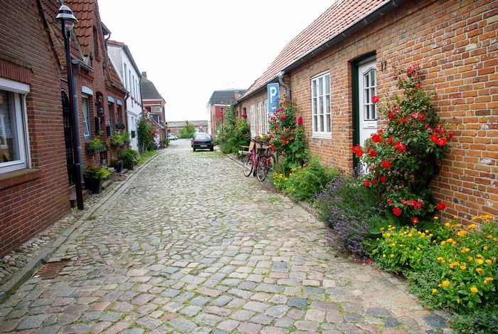 Cobblestone street in a German village with brick houses and flowers