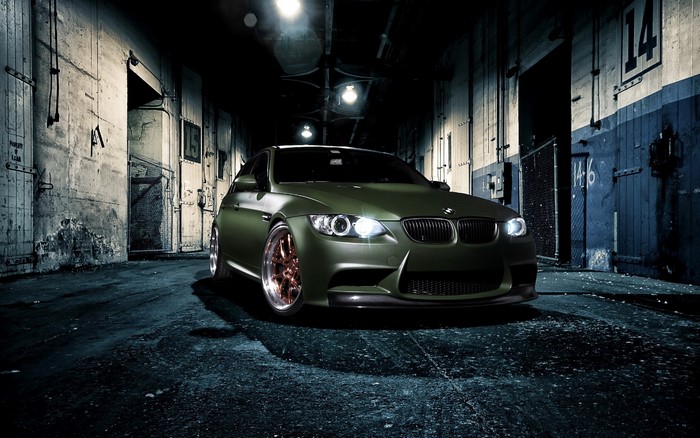 Matte green BMW M3 parked in an industrial alley
