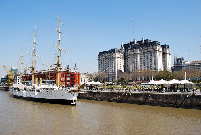 Tall ship docked in Puerto Madero, Argentina with large buildings