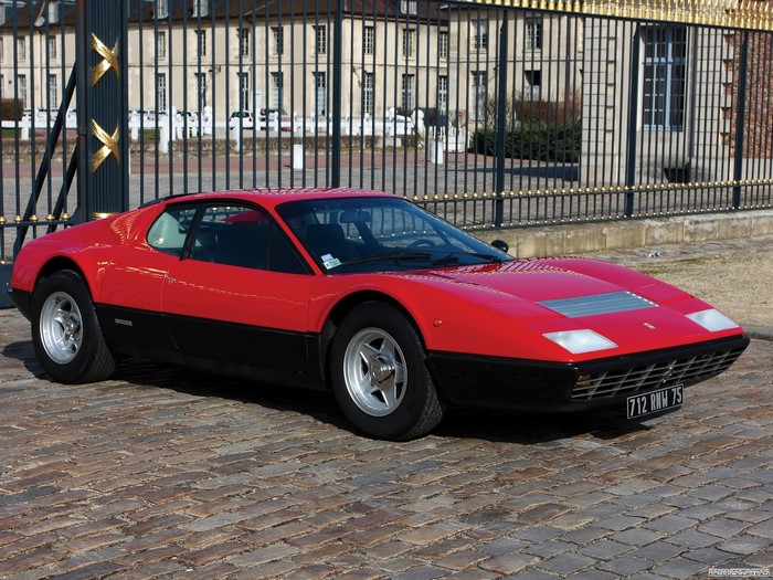 Red Ferrari 512 BB parked in front of a building