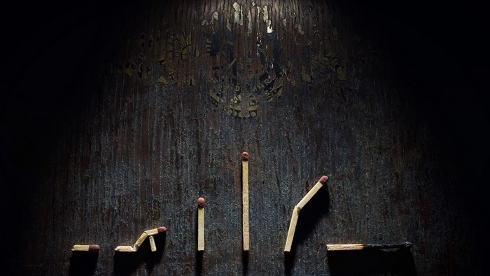 Matches arranged in a progression on a dark wooden surface