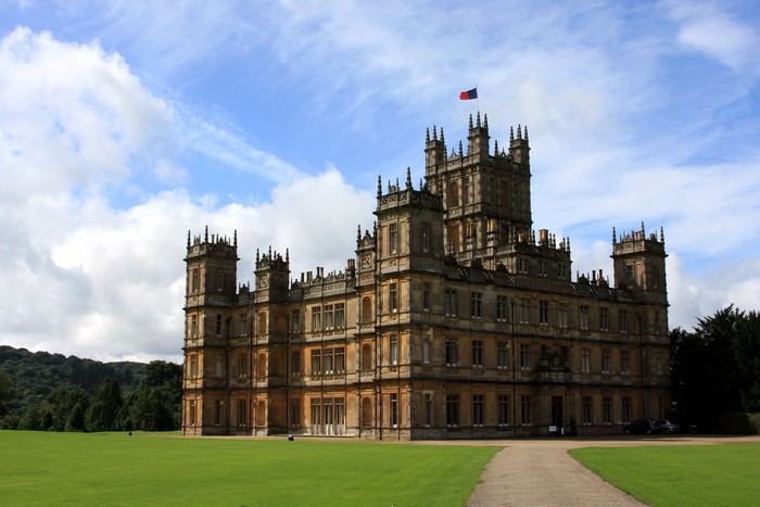Highclere Castle with flag under blue sky