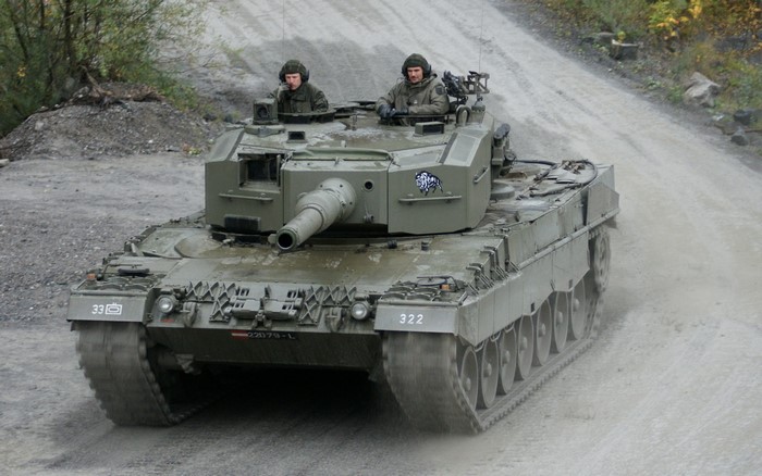 Leopard 2 tank with crew on a dirt road