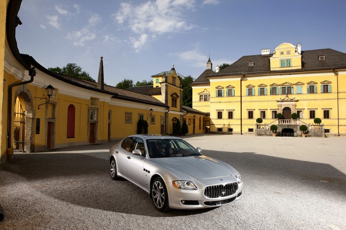 Maserati Quattroporte S parked in front of a yellow building