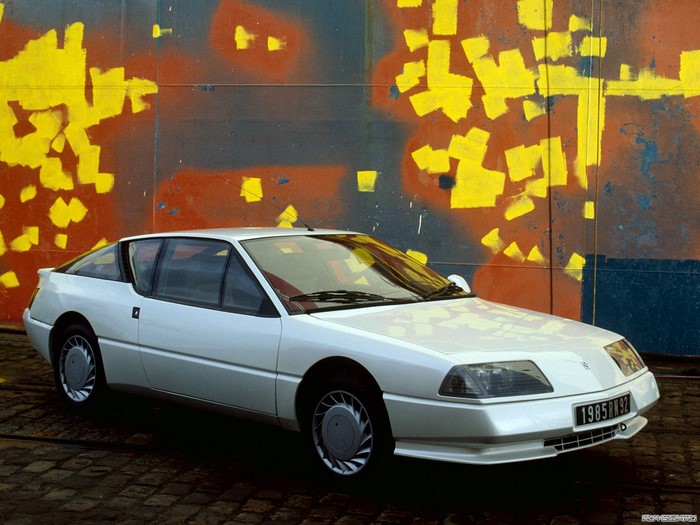 White Renault Alpine GTA parked in front of graffiti wall