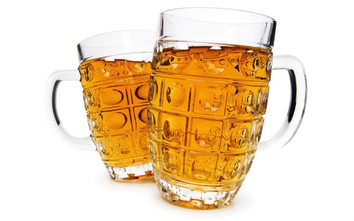 Two beer mugs filled with golden beer