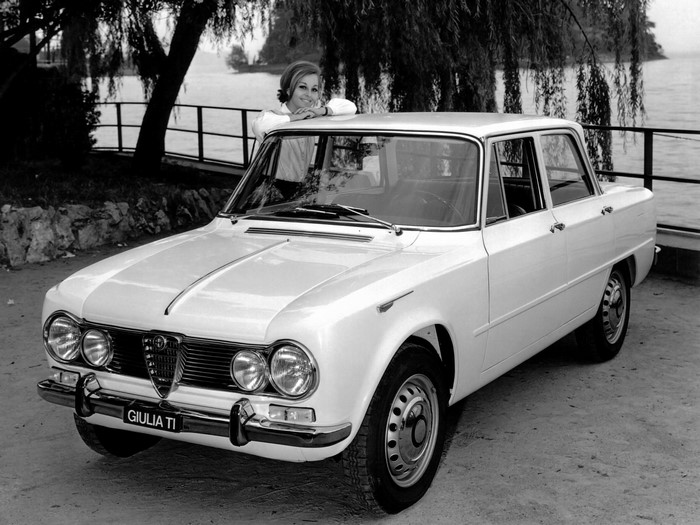 Woman leaning on a white Alfa Romeo Giulia TI car