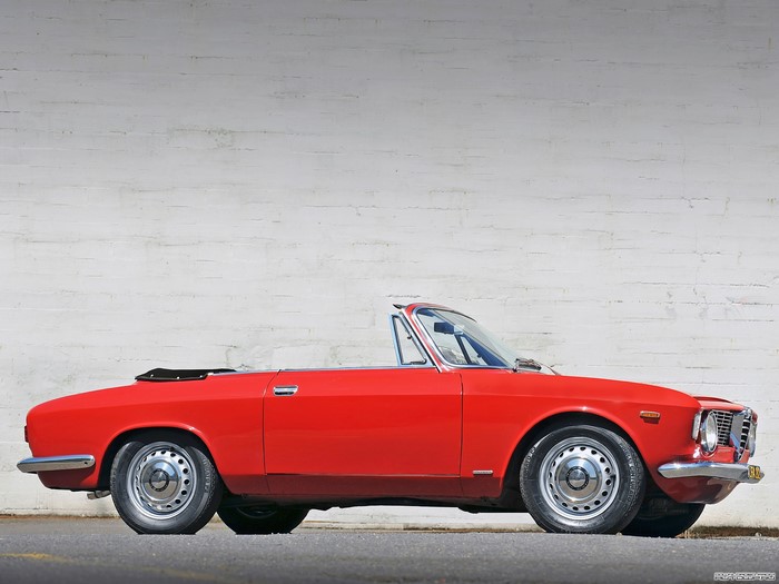 Red Alfa Romeo Convertible parked against a white brick wall