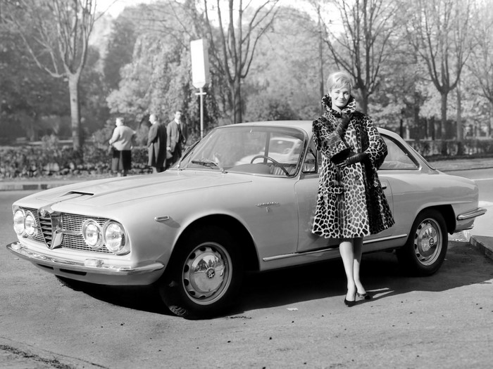 Woman in leopard print coat with Alfa Romeo car