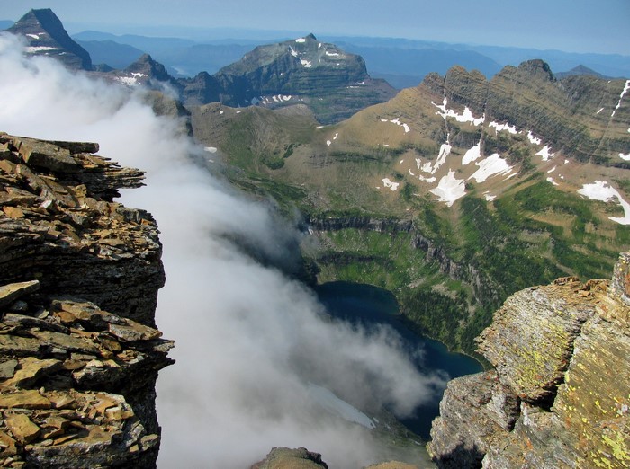 Mountain peaks with clouds and a lake in Glacier National Park