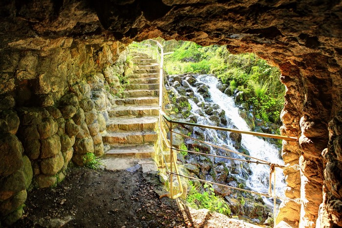 Stone staircase and waterfall inside a cave