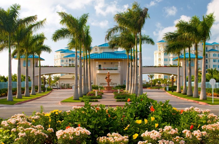 Seven Stars Resort entrance with palm trees and flowers
