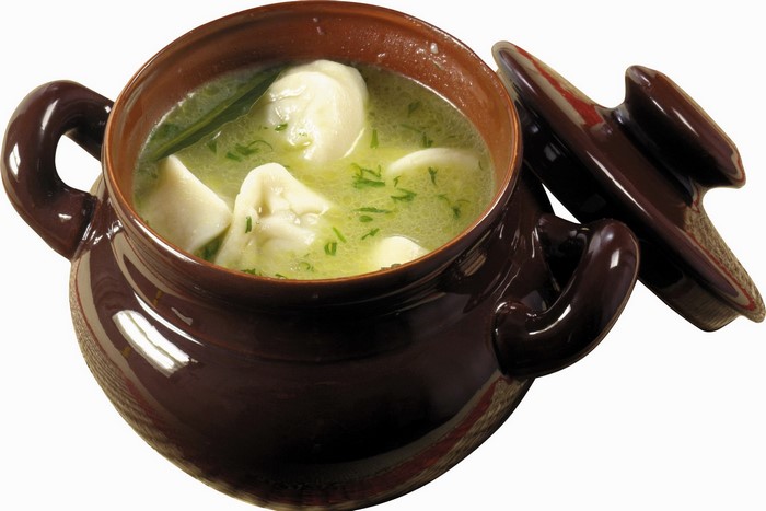 Dumplings in broth in a ceramic pot