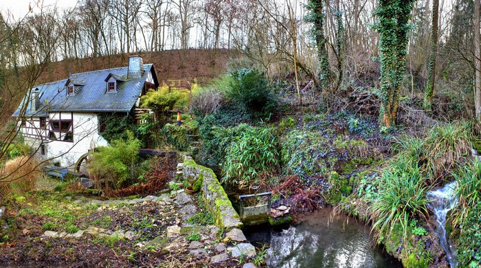 Old mill house by a stream in a forest, Germany