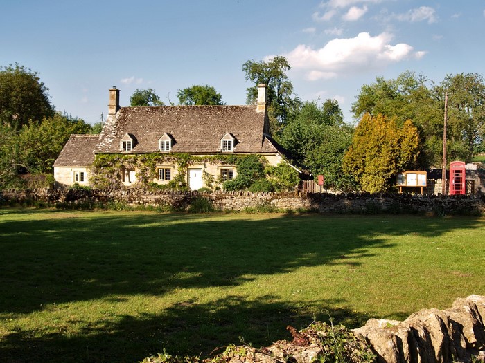 Stone cottage with red phone box in the UK