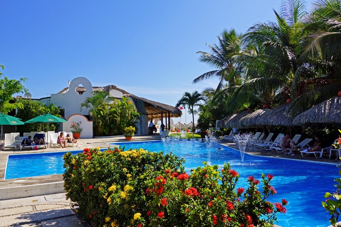 Resort pool with palm trees and lounge chairs in Mexico