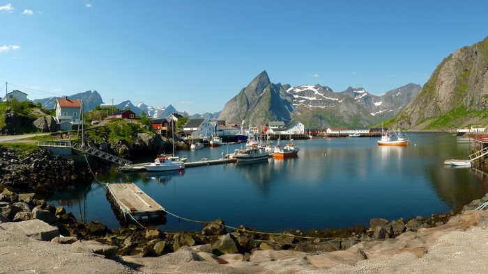 Fishing village with boats and mountains in Norway