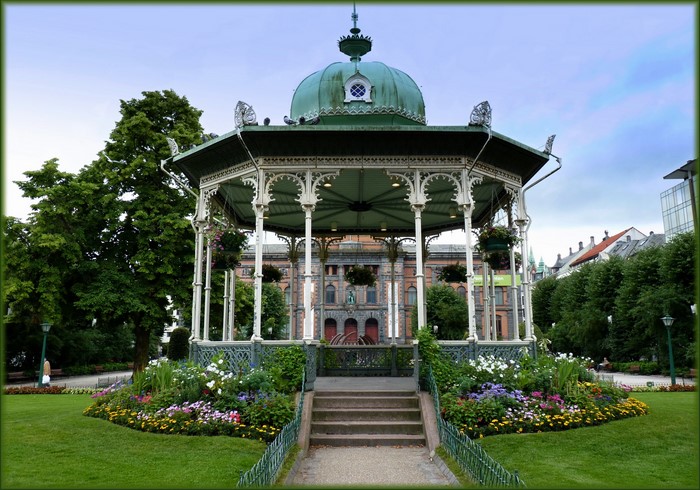 Gazebo in a park with a building in the background